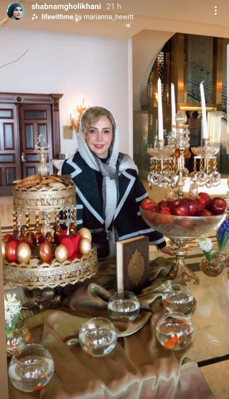 شبنم قلی خانی در کنار سفره هفت سین ساده و زیبایش عکس گرفته است.